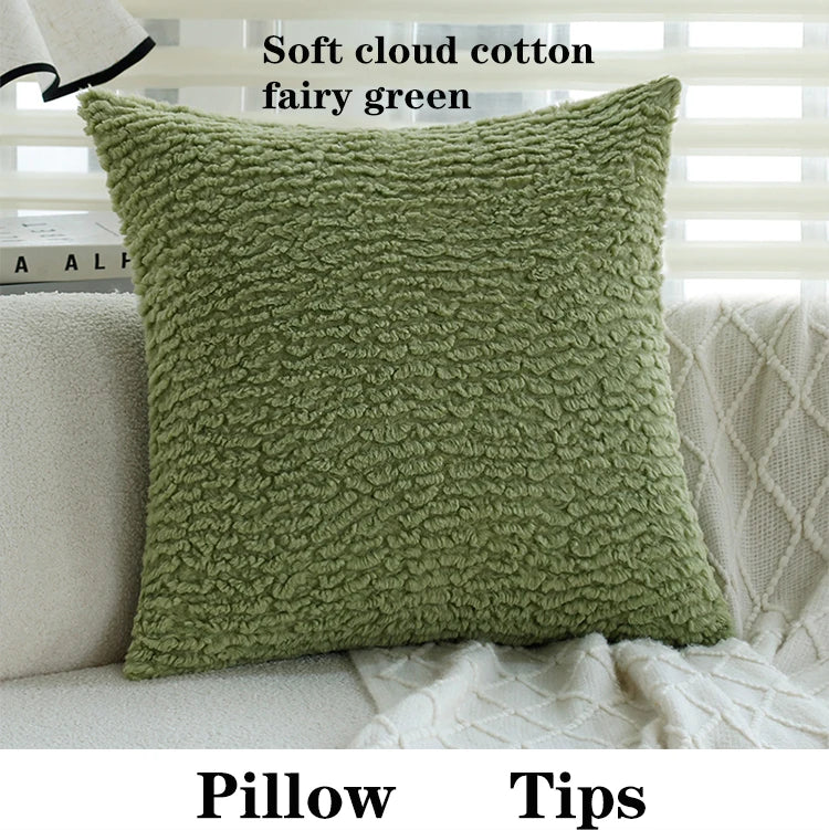A soft cloud cotton fairy green pillow with a textured fabric resting on a light-colored sofa.