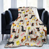 A tan and yellow patterned flannel blanket draped over a dark gray sofa.