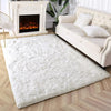 A fluffy white tie-dyed plush floor mat placed in front of a cream upholstered sofa and a white fireplace.