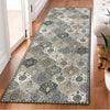 A rectangular vintage trellis rug runner featuring a distressed gray and beige pattern on a wooden floor.
