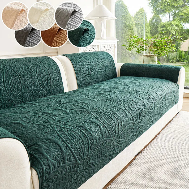 A dark green quilted sofa cushion with a white trim and decorative fabric swatches displayed above.