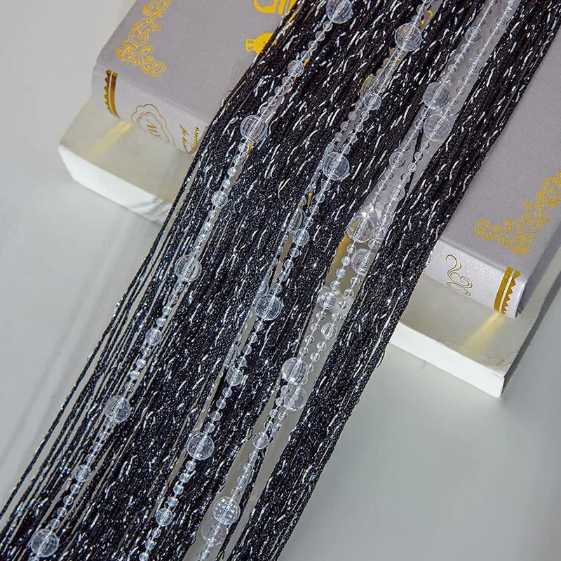 Black beaded string curtains with clear crystal beads displayed next to a box.