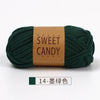 A skein of dark green hand-dyed fabric strip yarn labeled Sweet Candy Yarns.