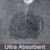 A close-up shot of a clear liquid dripping onto a dark gray ultra absorbent memory foam bathroom mat.
