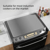 A black induction cooktop cover mat is shown resting on a stovetop.