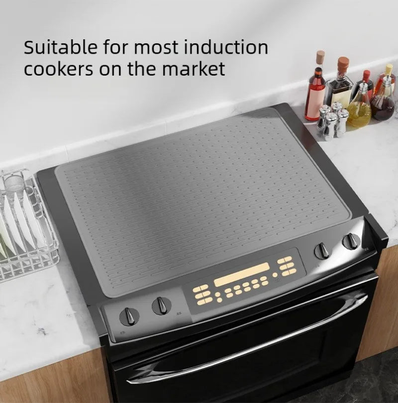 A black induction cooktop cover mat is shown resting on a stovetop.