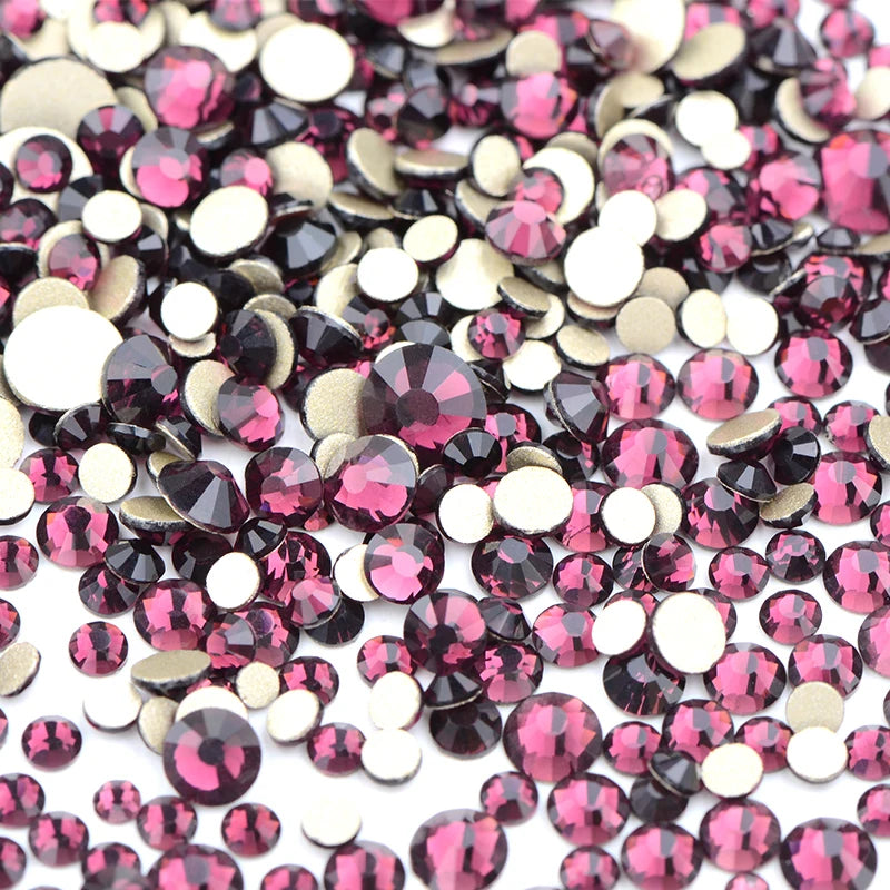 A pile of mixed clear and pink glass rhinestones for DIY crafts.