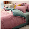 A luxurious flannel duvet cover set in shades of pink, teal, and mustard yellow is displayed on a bed.