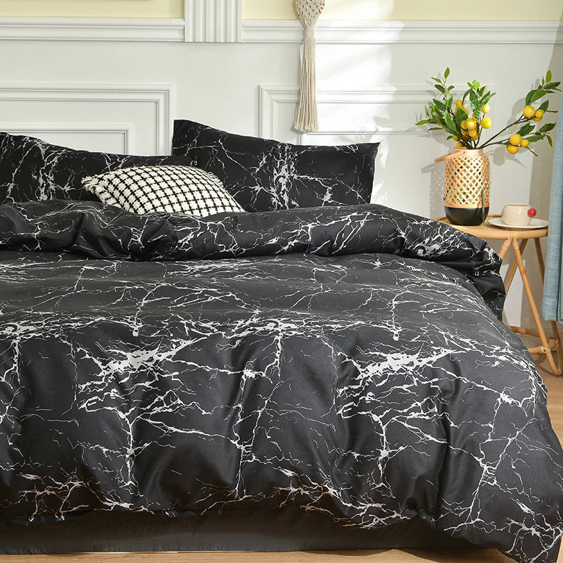 Black marble print duvet cover set with pillows displayed on a bed against a light wall.