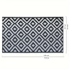 A black and white geometric patterned outdoor rug with dimensions of 180 cm by 47.2 inches.