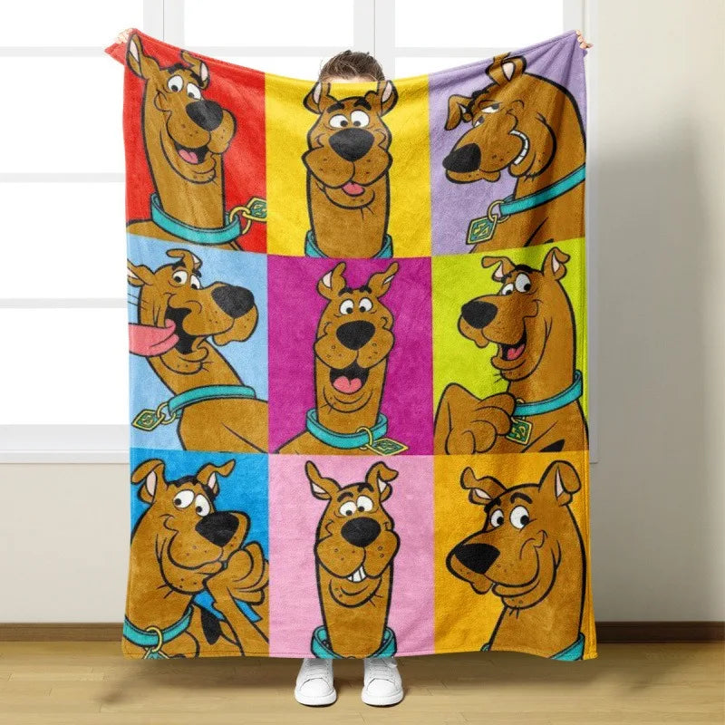 A colorful flannel throw blanket featuring various cartoon dogs from Scooby-Doo