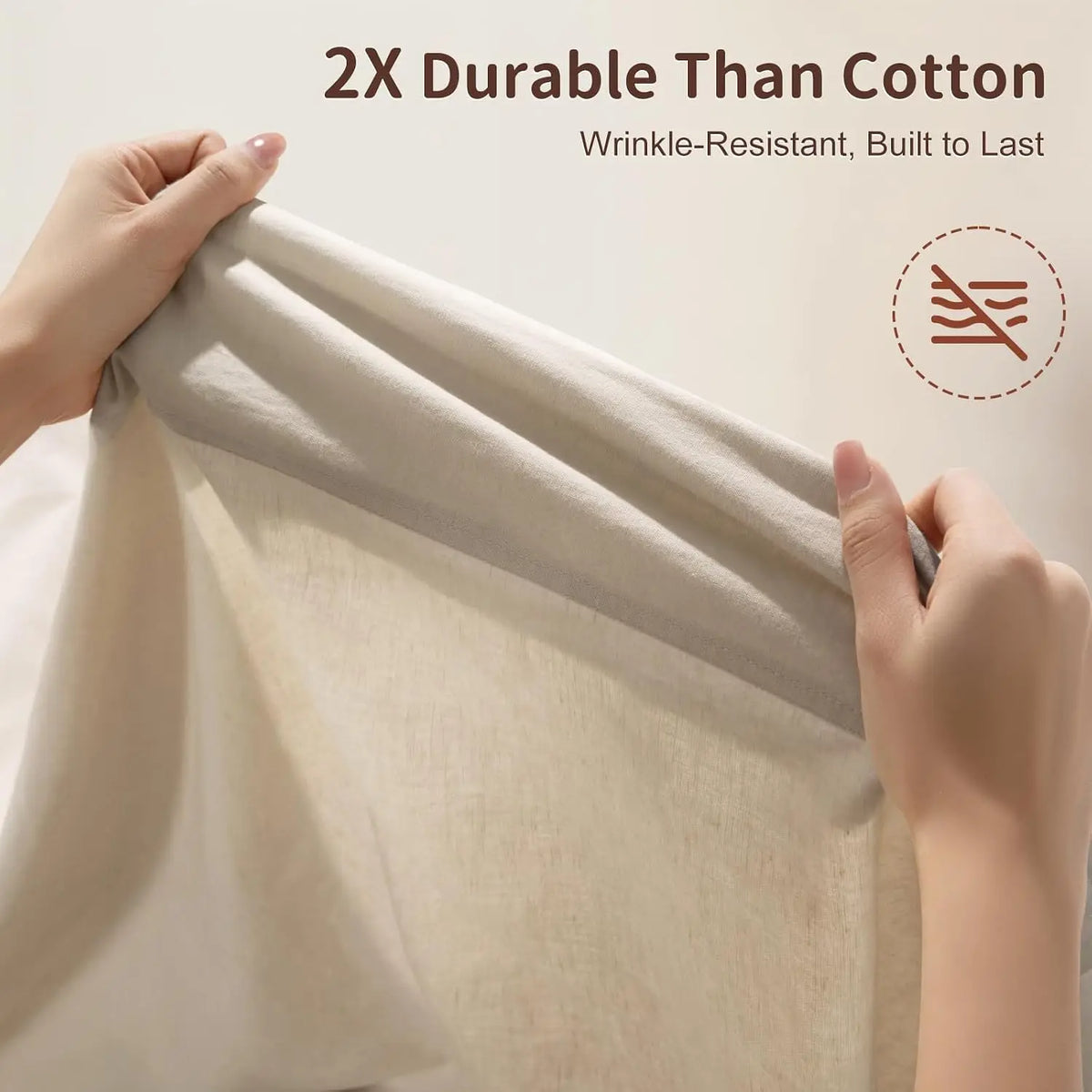 Hands are folding a light beige linen bed sheet, demonstrating its wrinkle-resistant quality.