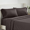 A dark brown striped bedding set featuring two pillows and a fitted sheet on a white upholstered bed.