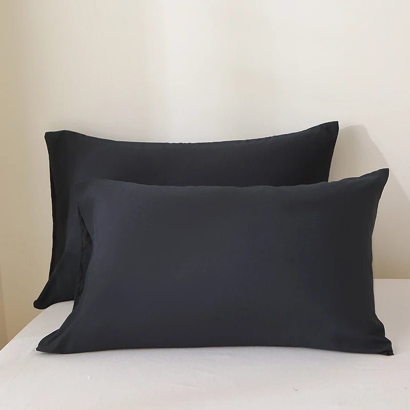 A set of three black luxury polyester pillow covers displayed on a white surface.