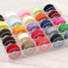 A plastic container holds an assortment of colorful sewing thread bobbins in various shades and colors.