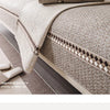 A close-up of a beige linen sofa cover featuring a textured fabric and decorative piping.