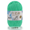 A ball of bright green milk cotton yarn with a label in Chinese and English.