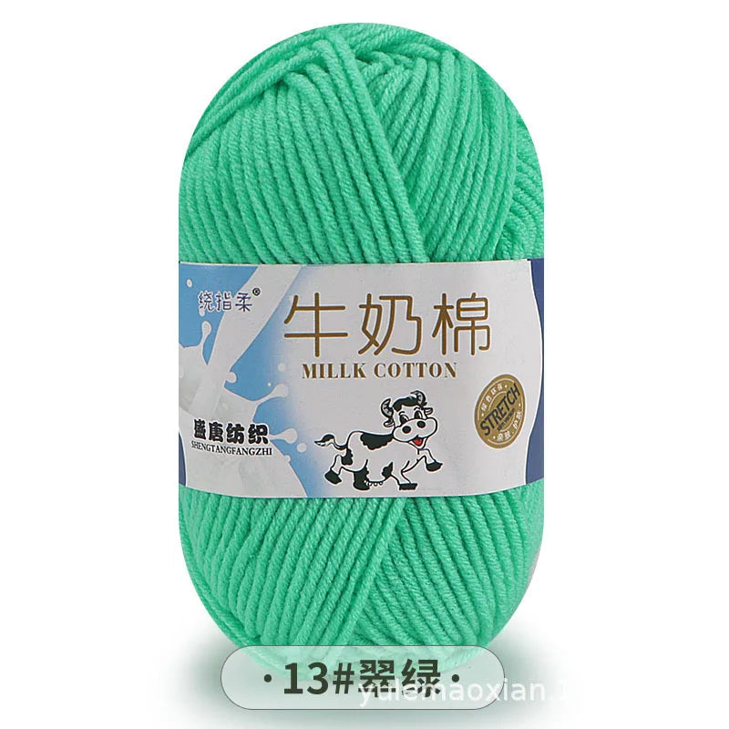 A ball of bright green milk cotton yarn with a label in Chinese and English.