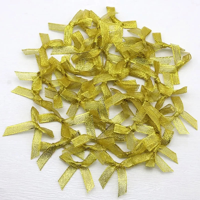 A pile of small, gold satin ribbon bows for crafts and decor.