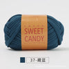 A skein of dark teal hand-dyed fabric strip yarn labeled SWEET CANDY with Chinese characters.