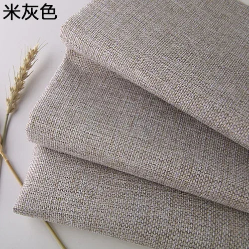 Stack of coarse linen and cotton fabric in a natural gray color, showing texture and weave.