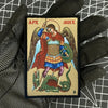 A embroidered patch depicting the Archangel Michael with wings and a sword, featuring red and blue colors.