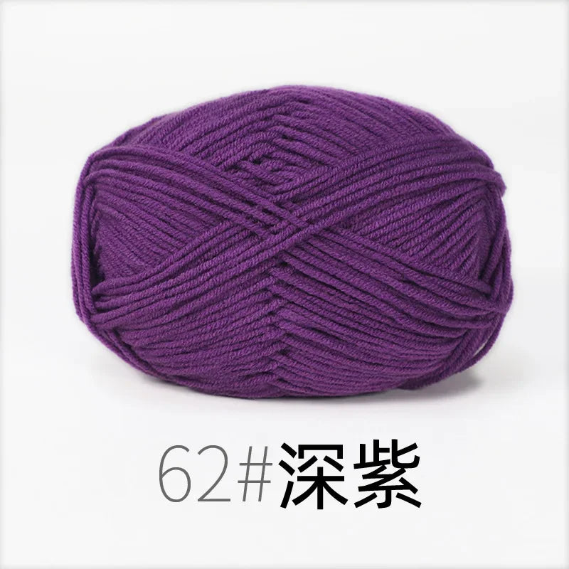 A ball of deep purple organic cotton 4ply knitting yarn labeled as size 62