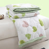 White duvet cover with light green and pink floral patterns folded on a white surface.