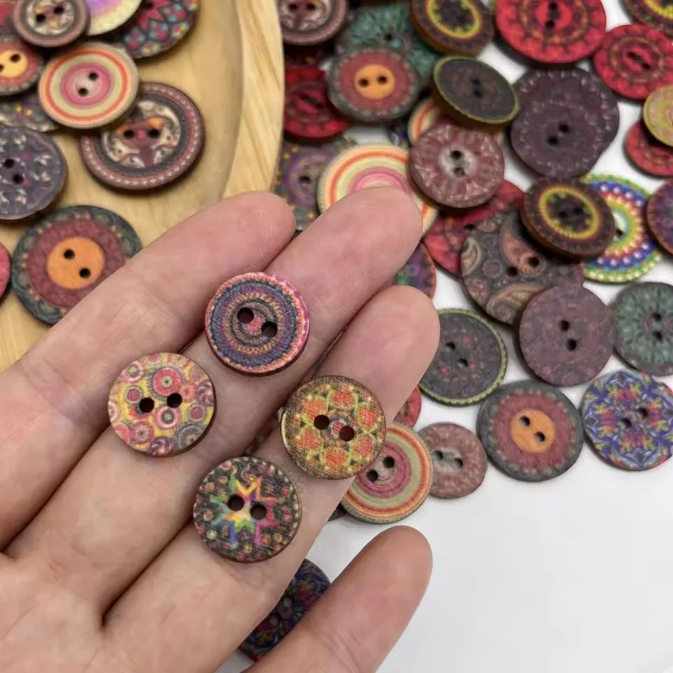 A hand holds numerous vintage wooden buttons in various colors and patterns.