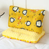 A yellow fiber pillow featuring a cartoon animal design, placed on white bedding.