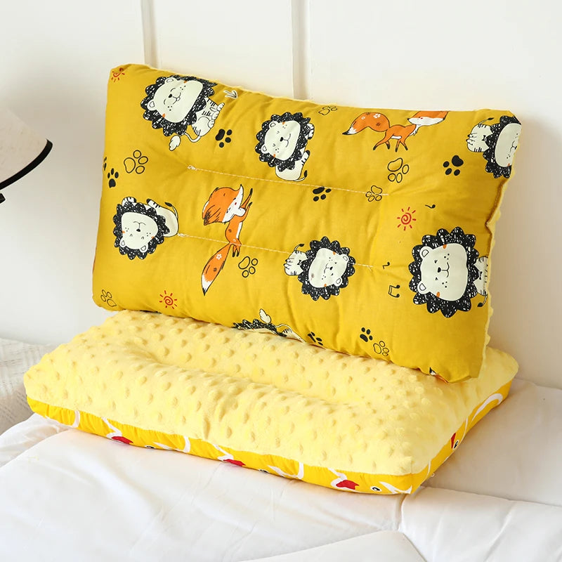 A yellow fiber pillow featuring a cartoon animal design, placed on white bedding.