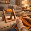 A person is using a wooden rotating yarn storage rack to wind orange yarn for knitting or crafting.