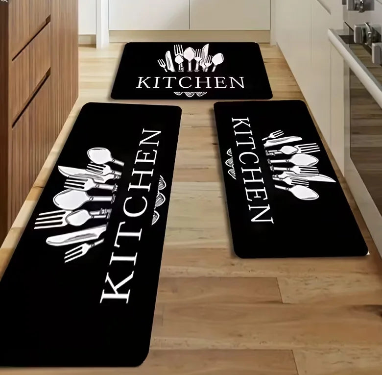 Black non-slip flannel area rugs with white cutlery designs placed on a light wood floor.