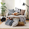A collection of leopard print throw pillow covers in various shades and patterns displayed on a beige rug.