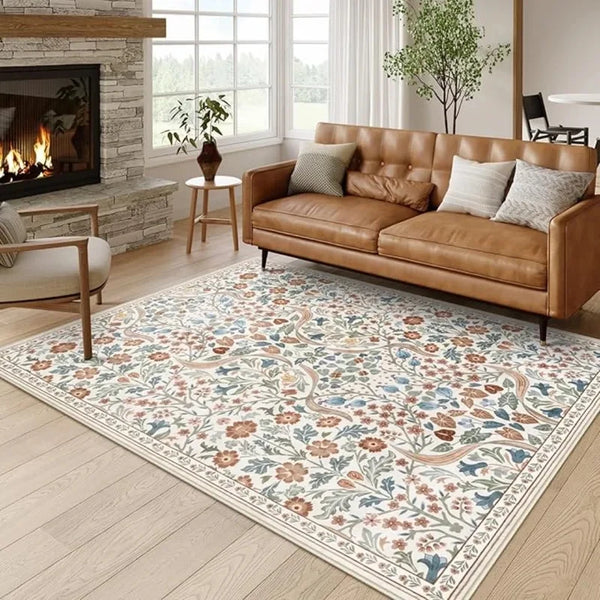 A vintage floral living room rug featuring soft peach, blue, and cream botanical patterns on a light wood floor.
