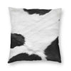 A square cushion cover made of faux fur cowhide print featuring black and white patches.