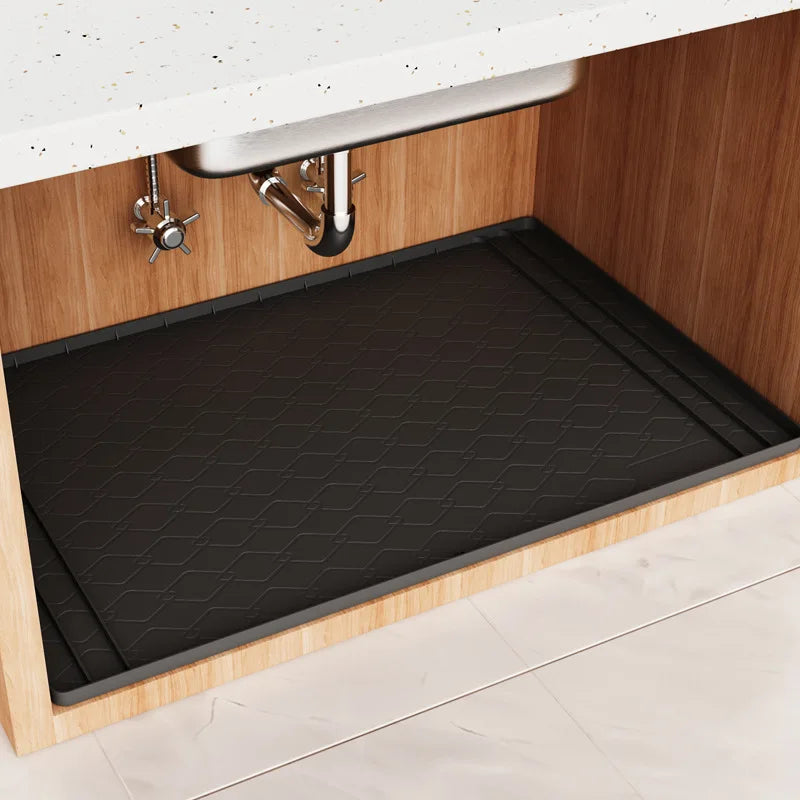 A black silicone liner is installed in an under sink cabinet to protect the surface.
