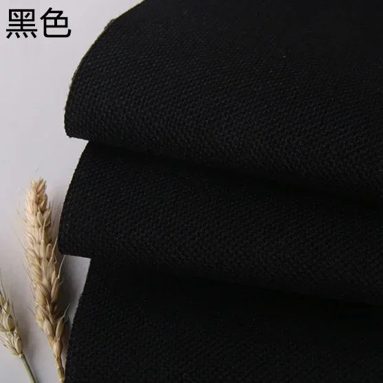 Black coarse linen and cotton fabric rolled up, showing texture.