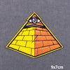 A triangular embroidery patch featuring an eye design with yellow and orange checkered patterns.
