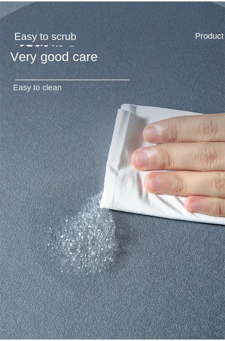 A hand is rubbing a white cloth on a gray surface, showing a fine white powder or residue being cleaned.