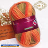 A ball of gradient dyed wool yarn in shades of orange, green, and yellow is shown next to a wooden box.