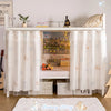 A white double-layer mesh bed canopy with lace trim featuring a wooden headboard and decorative fabric panels.