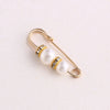 Gold-toned adjustable pearl brooch featuring round pearls accented with small clear stones