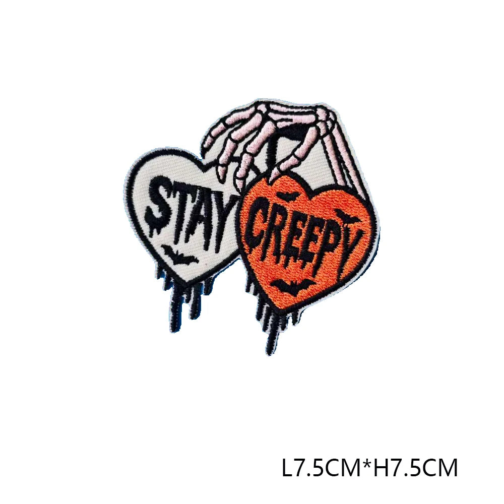 Iron-on patch featuring a hand shape with the text STAY CREEPY embroidered in orange and black thread
