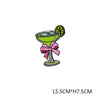 A green glass cocktail with a lime garnish and a pink bow decoration.
