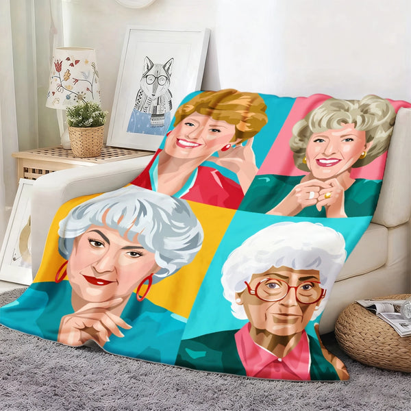 A colorful blanket featuring portraits of three elderly women in a retro pop art style.