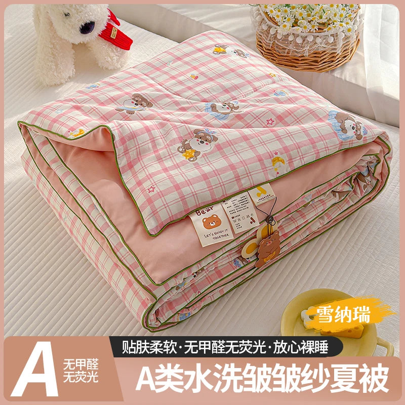 A lightweight summer quilt with a pink and white checkered pattern featuring cartoon animals.