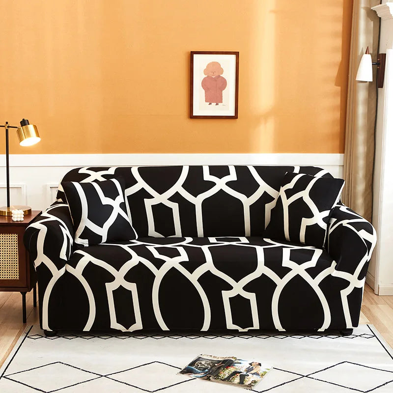 A black and white patterned universal stretch sofa slipcover placed on a light rug in an interior room.