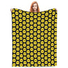 A black and yellow patterned plush throw blanket featuring cartoon faces.