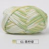 A ball of hand-dyed fabric strip yarn in pale green and cream colors, coiled for crochet or knitting.